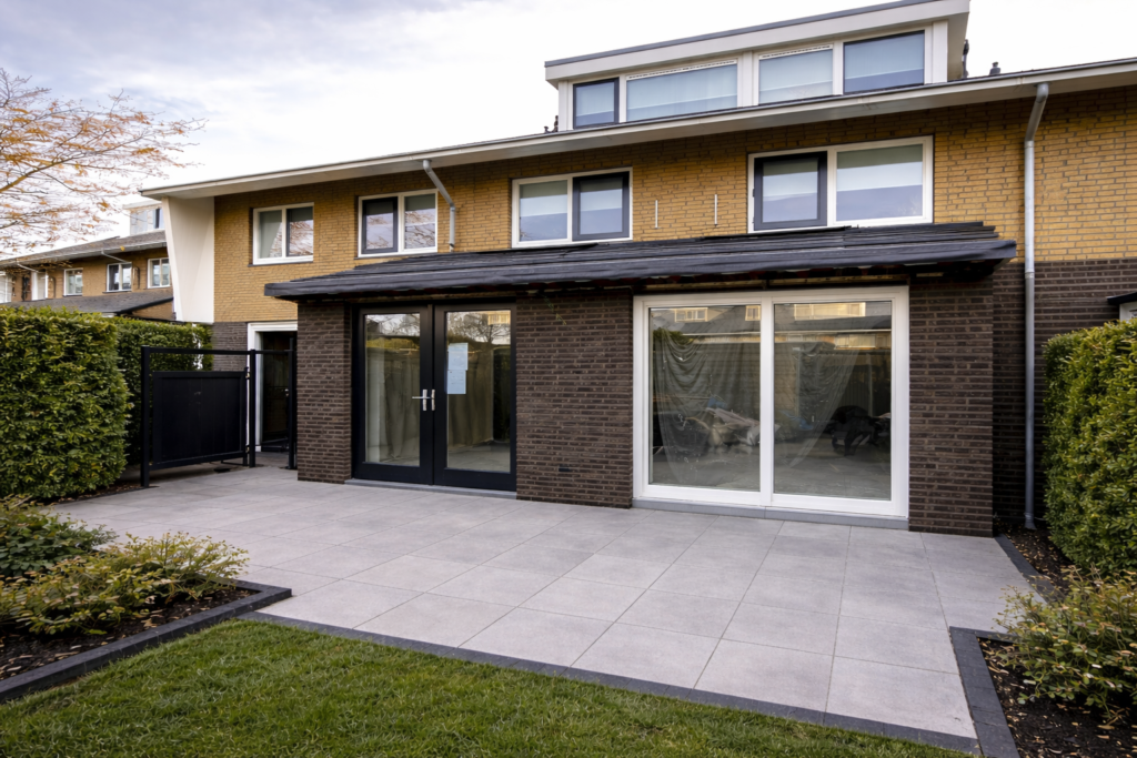 Moderne aanbouw huis met grote raampartij en terras — Wolfe Bouw